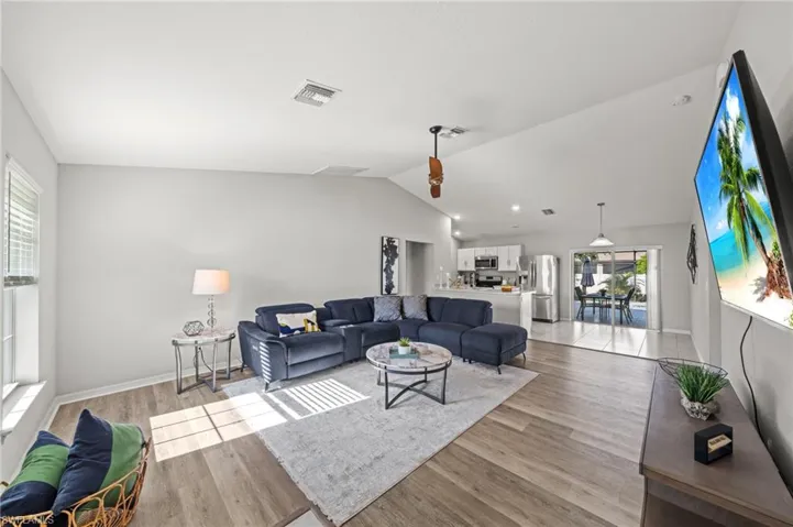 Living room with lofted ceiling and light wood-style floors