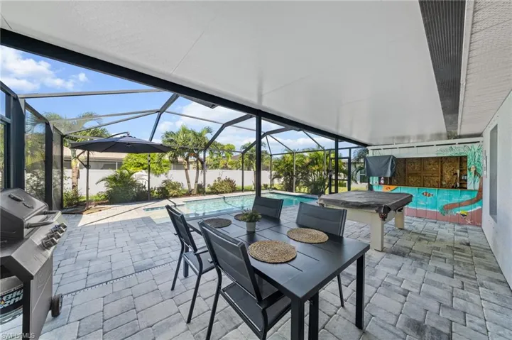 View of patio featuring an outdoor pool, a sunroom, a lanai, a grill, and outdoor dining area