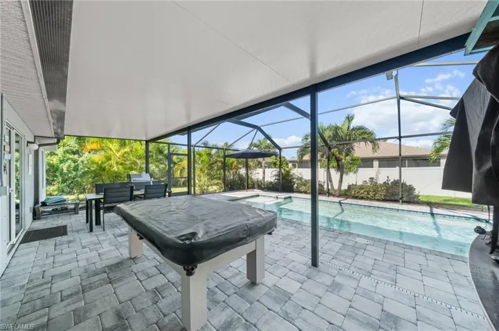 View of swimming pool featuring a patio area, a sunroom, and a lanai