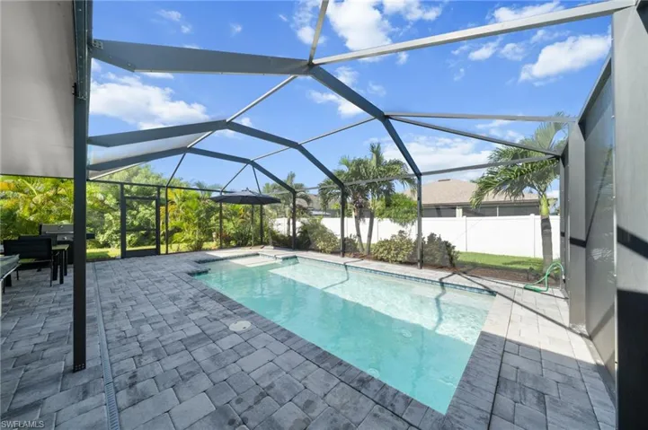 View of swimming pool with a sunroom, glass enclosure, and a patio