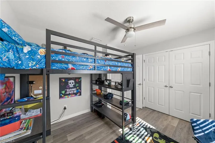 Bedroom featuring light wood finished floors, a ceiling fan, and a closet