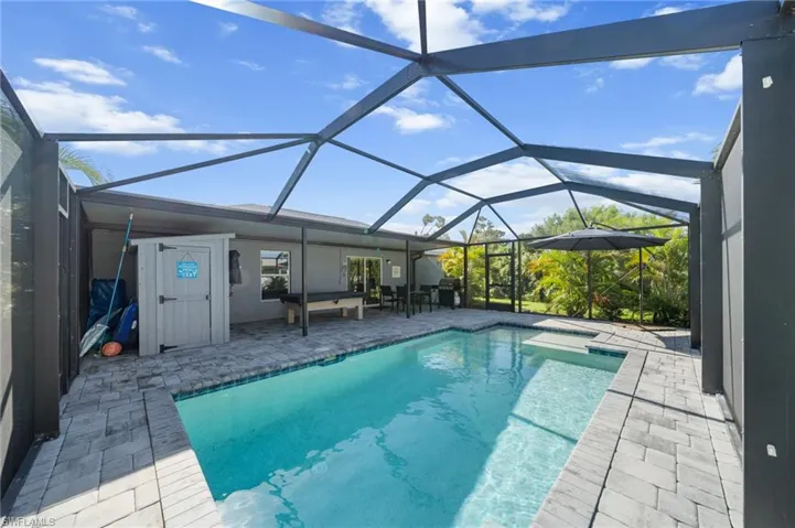 Swimming pool featuring a patio, a sunroom, and a lanai