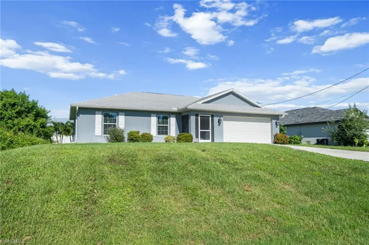 Ranch-style house featuring stucco siding, a front lawn, driveway, and an attached garage