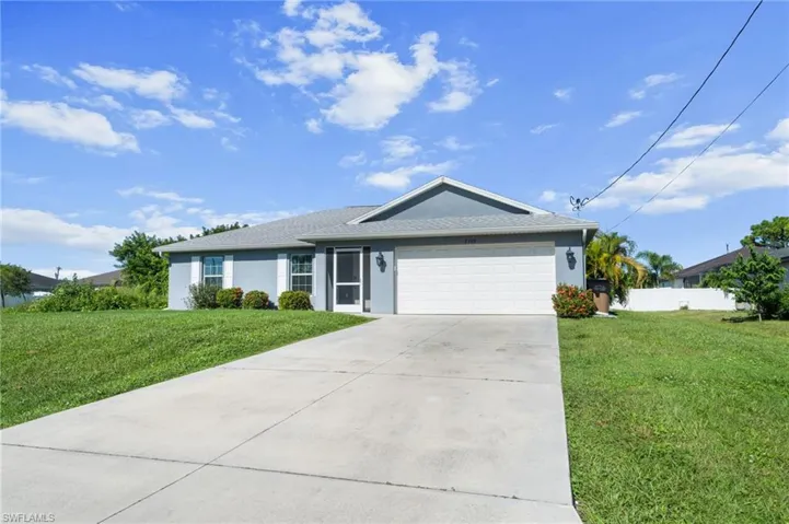 Ranch-style house with stucco siding, a front yard, an attached garage, and concrete driveway