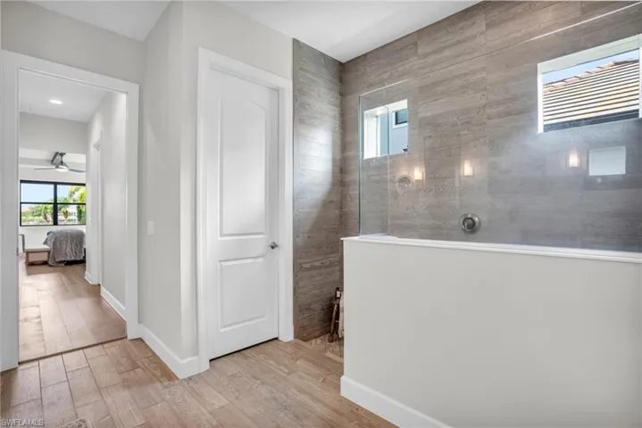 Primary bathroom with large walk-in tiled shower, and hardwood flooring