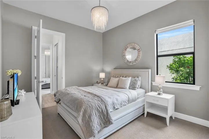 Carpeted bedroom 3 with an inviting chandelier