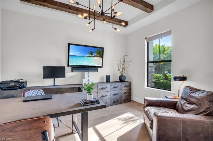 Office area with beamed ceiling, a chandelier, light hardware flooring, and a raised ceiling