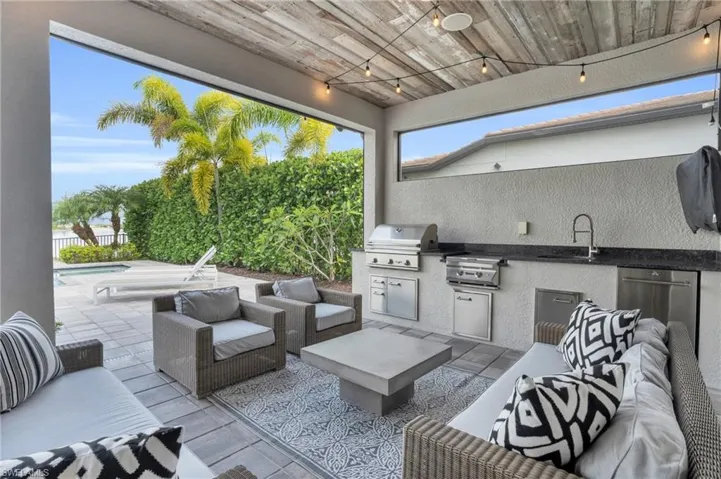 View of patio with a grill, an outdoor hangout area, exterior kitchen, a fenced in pool, and sink