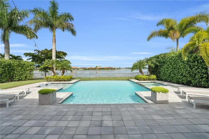 View of pool featuring a patio and view of lake