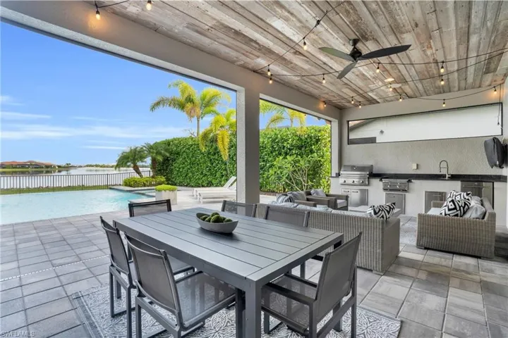 View of patio / terrace featuring reclaimed wood detail on ceiling with fan, an outdoor living space, area for grilling, a fenced in pool, and a grill
