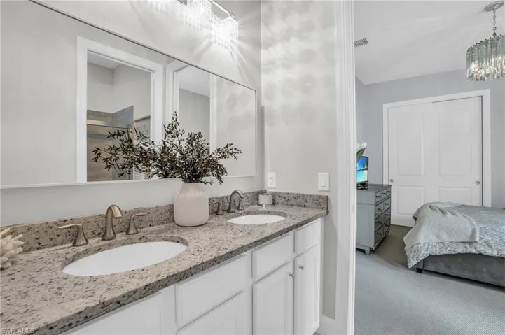 Bathroom 2 (jack & jill) featuring double vanity and an inviting chandelier