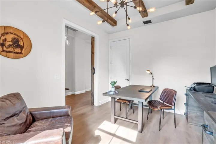 Office space with a notable chandelier and hardwood floors