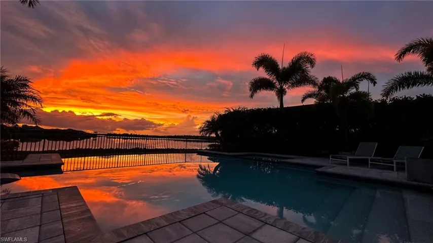 View of pool at dusk with lake view