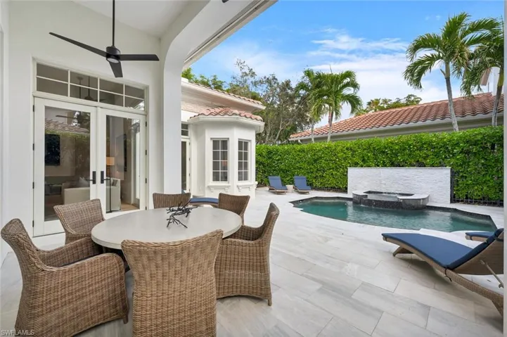 View of patio / terrace featuring french doors, a pool with hot tub, and ceiling fan