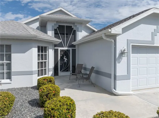 Doorway to property featuring an attached garage and stucco siding
