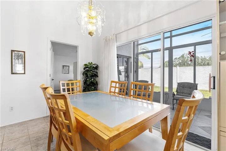 Dining space featuring a chandelier, healthy amount of natural light, light tile patterned floors, and baseboards