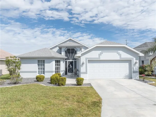 Ranch-style home with a garage, a front yard, concrete driveway, stucco siding, and cooling unit
