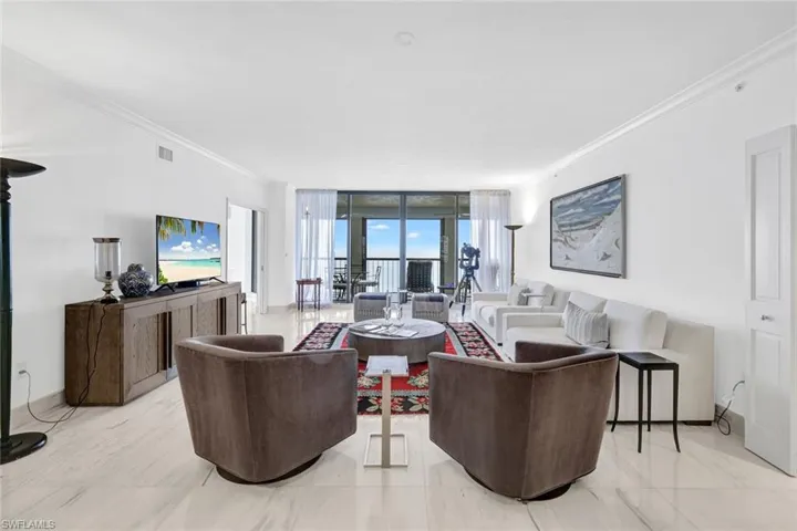Living room with crown molding, expansive windows, and light marble finish flooring
