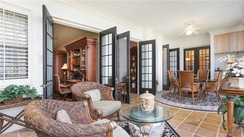 Living area featuring french doors, tile patterned floors, crown molding, ceiling fan, and a healthy amount of sunlight