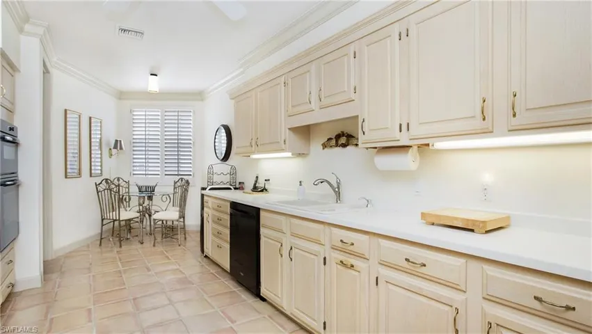 Kitchen with cream cabinets, ornamental molding, dishwasher, and sink
