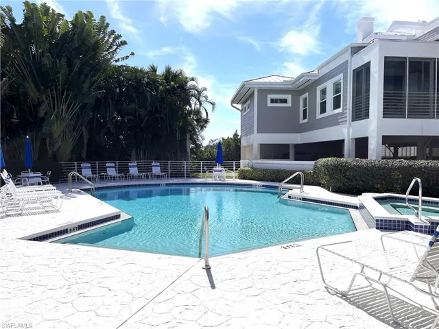 View of pool with a patio area and a community hot tub