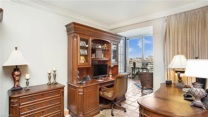 Home office with expansive windows, crown molding, and light tile patterned floors