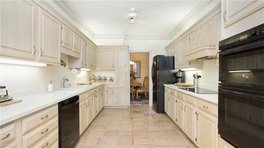 Kitchen featuring sink, ornamental molding, ceiling fan, cream cabinets, and black appliances