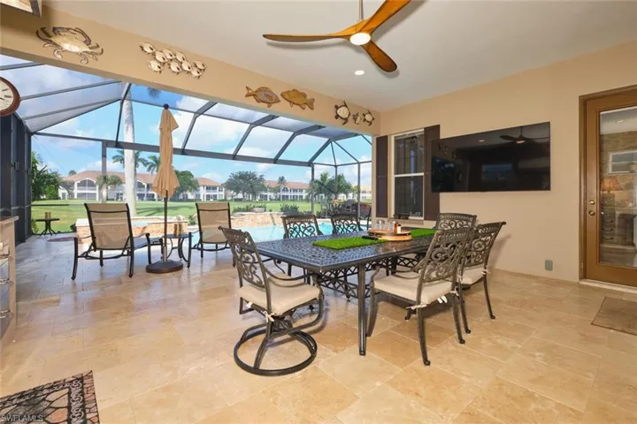 View of patio / terrace featuring a sunroom, a ceiling fan, a lanai, and outdoor dining area