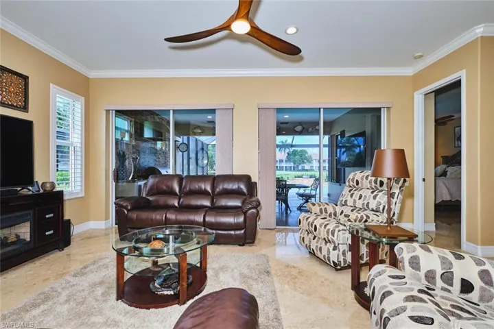 Living area with plenty of natural light, crown molding, ceiling fan, and recessed lighting