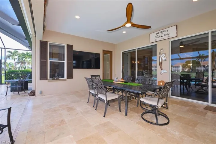View of patio / terrace featuring outdoor dining space, ceiling fan, and a sunroom