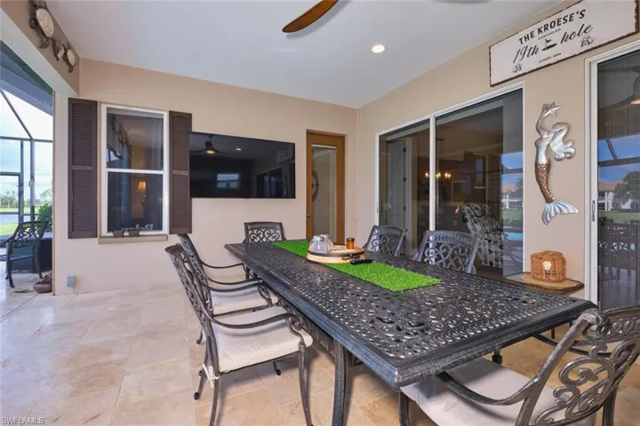 View of patio / terrace featuring outdoor dining area, ceiling fan, glass enclosure, and a sunroom