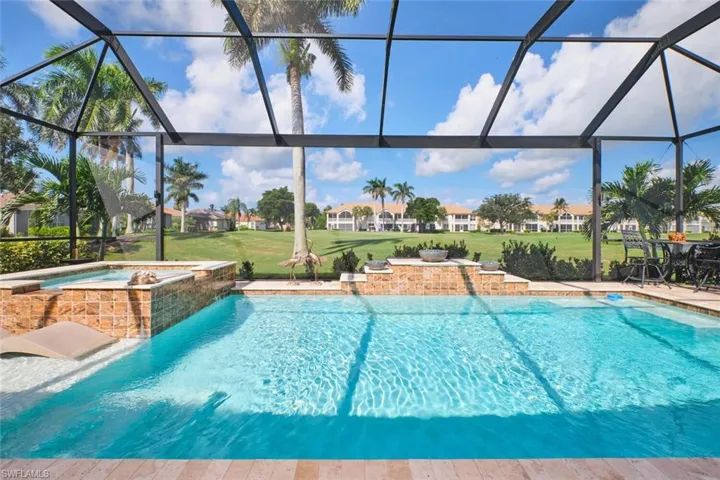 View of pool featuring a sunroom, a lawn, a pool with connected hot tub, and view of golf course