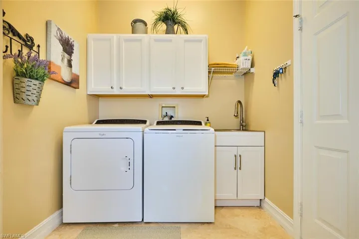 Washroom with cabinet space and washer and clothes dryer