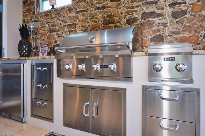 Detailed view of built in refrigerator and stone siding