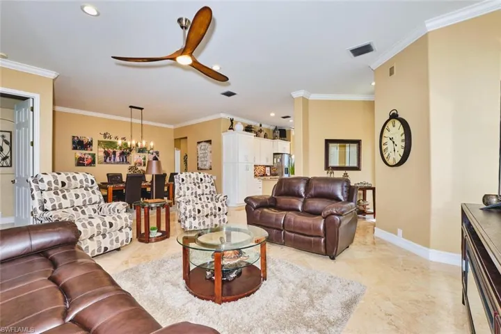 Living area with crown molding, ceiling fan, and recessed lighting