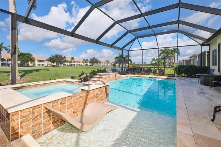 View of swimming pool featuring a lawn, a patio, a pool with connected hot tub, and a sunroom
