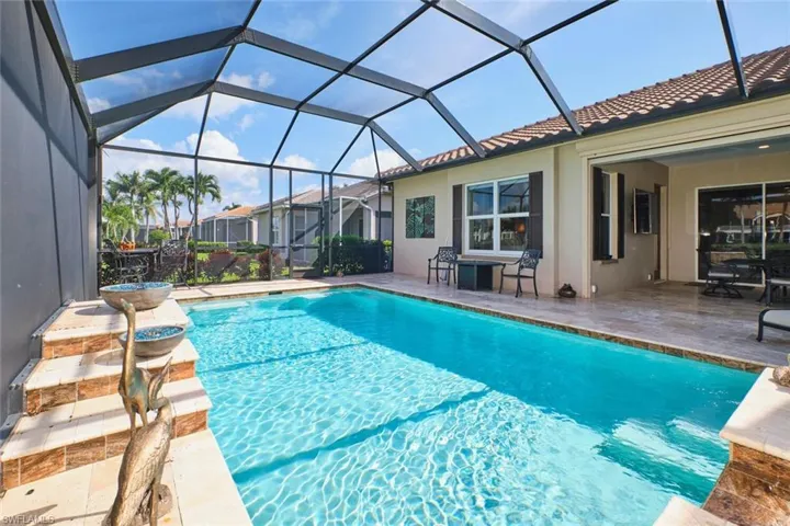 Swimming pool with a patio area, a sunroom, and glass enclosure