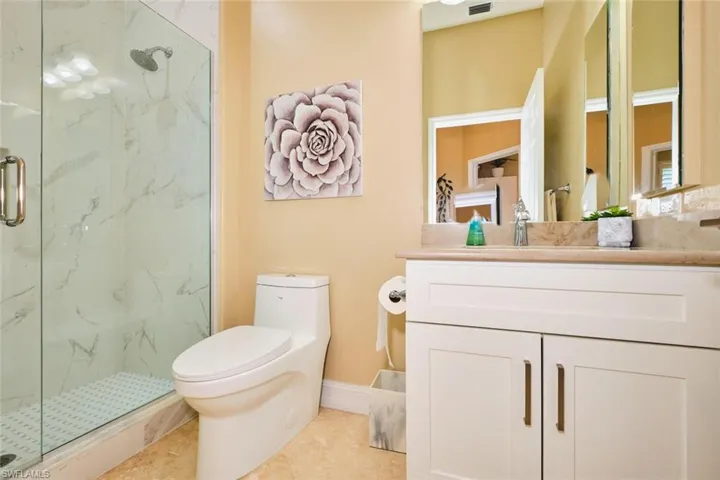 Full bath featuring a marble finish shower, vanity, and light tile patterned floors