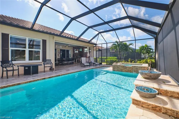 View of swimming pool with a patio, a sunroom, glass enclosure, a ceiling fan, and a pool with connected hot tub