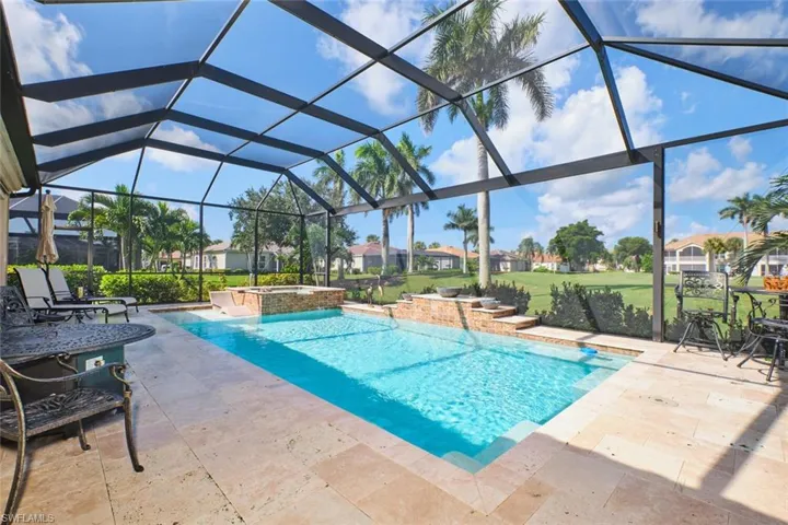 View of swimming pool featuring a residential view, a sunroom, a pool with connected hot tub, a patio area, and a lanai