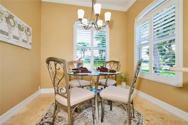 Dining area featuring healthy amount of natural light, ornamental molding, and a chandelier