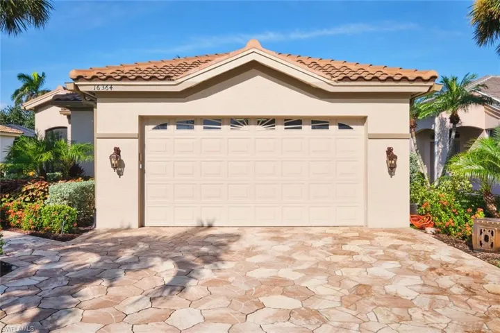 Mediterranean / spanish-style house with stucco siding, a tile roof, decorative driveway, and a garage