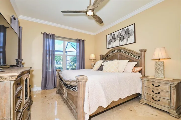 Bedroom with ornamental molding and a ceiling fan