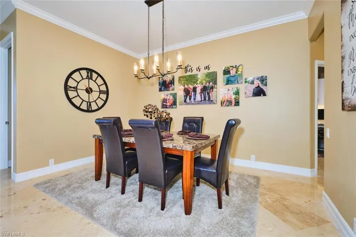 Dining space with crown molding and a chandelier