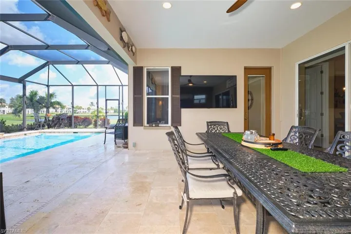 View of patio / terrace with a sunroom, an outdoor pool, a ceiling fan, and glass enclosure