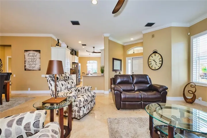 Living area featuring ceiling fan, ornamental molding, and recessed lighting