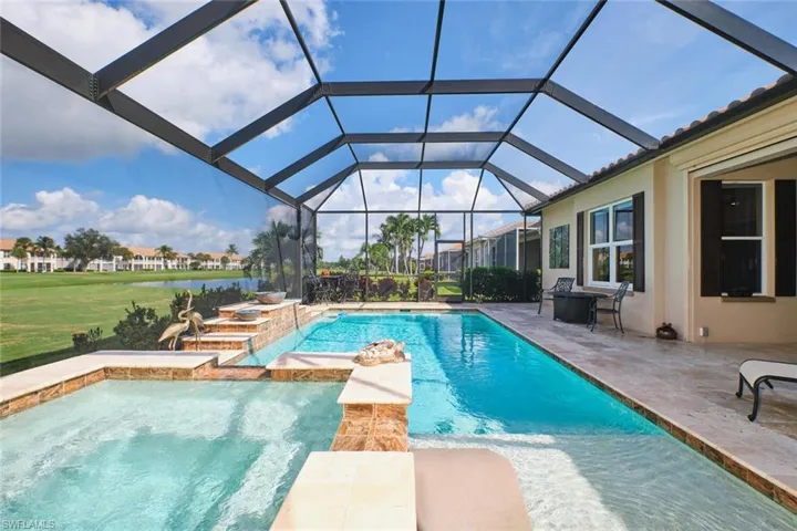 View of pool with a sunroom, a patio area, a water view, glass enclosure, and a pool with connected hot tub