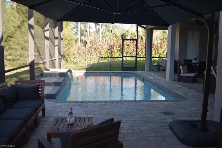 Outdoor pool featuring outdoor seating, a patio, a lanai, and a yard