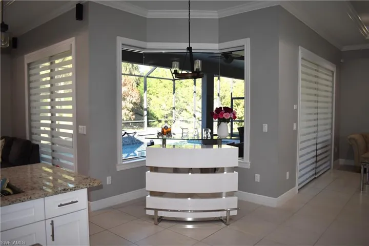 Dining room featuring ornamental molding, light tile patterned flooring, and a ceiling fan