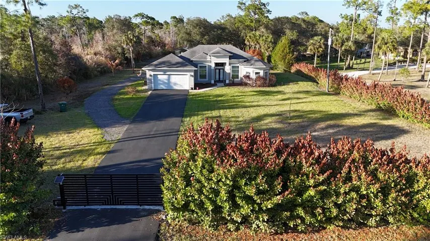 View of front facade featuring driveway, a front lawn, and an attached garage